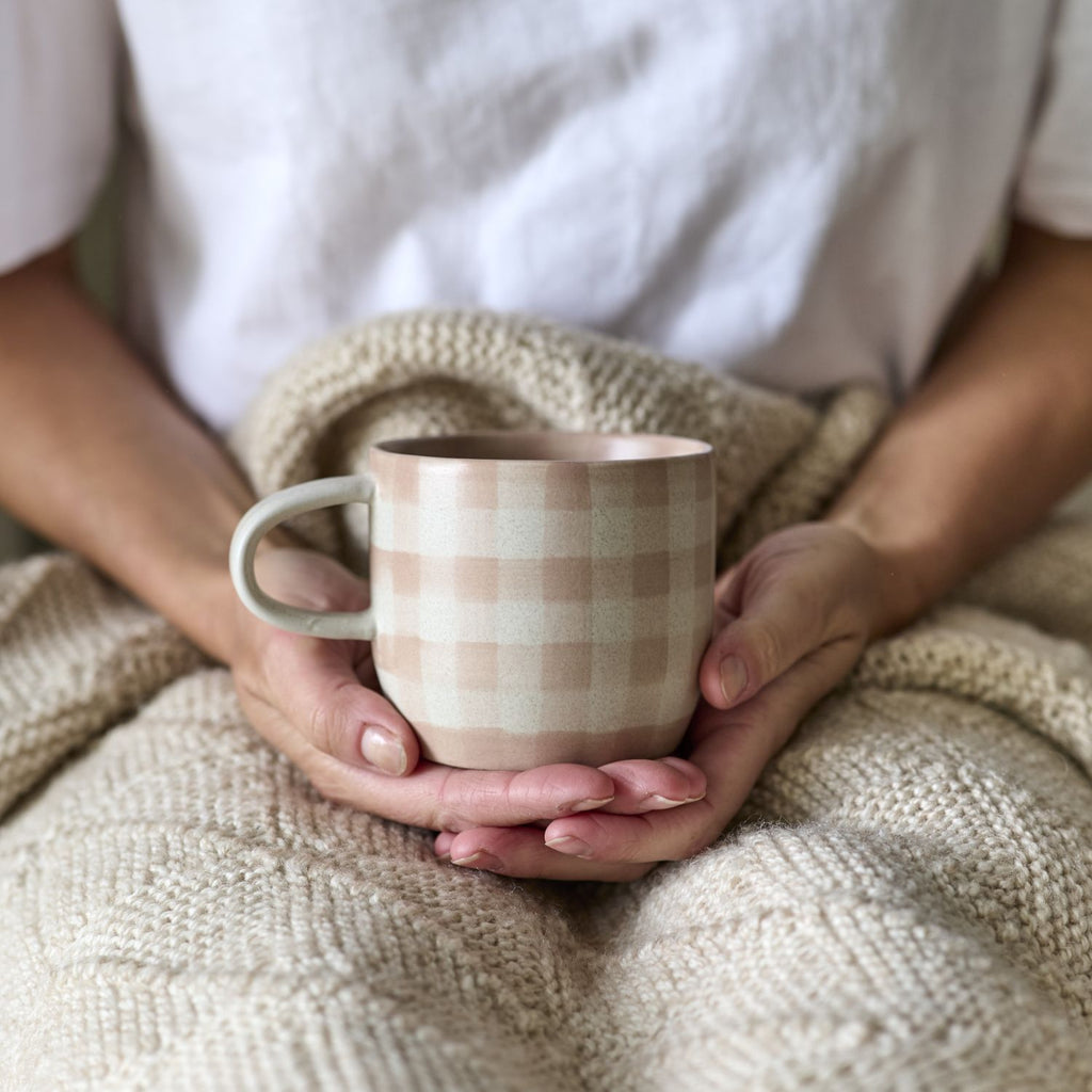 Twig and Feather - The Cat's Pyjamas mug in soft terracotta or dusty pink in a gingham check pattern - by Robert Gordon - being held by lady