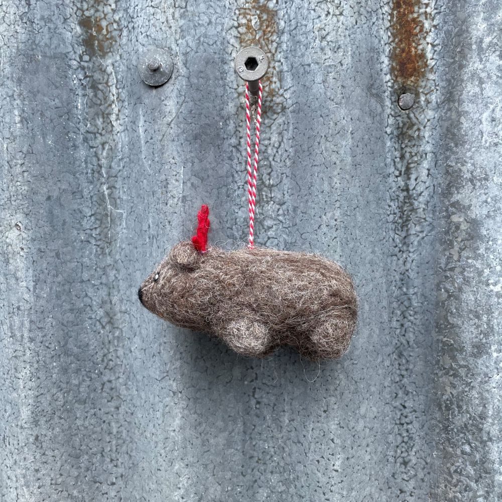 Small Felt Australian Wombat ornament with red antlers hanging on a metal surface