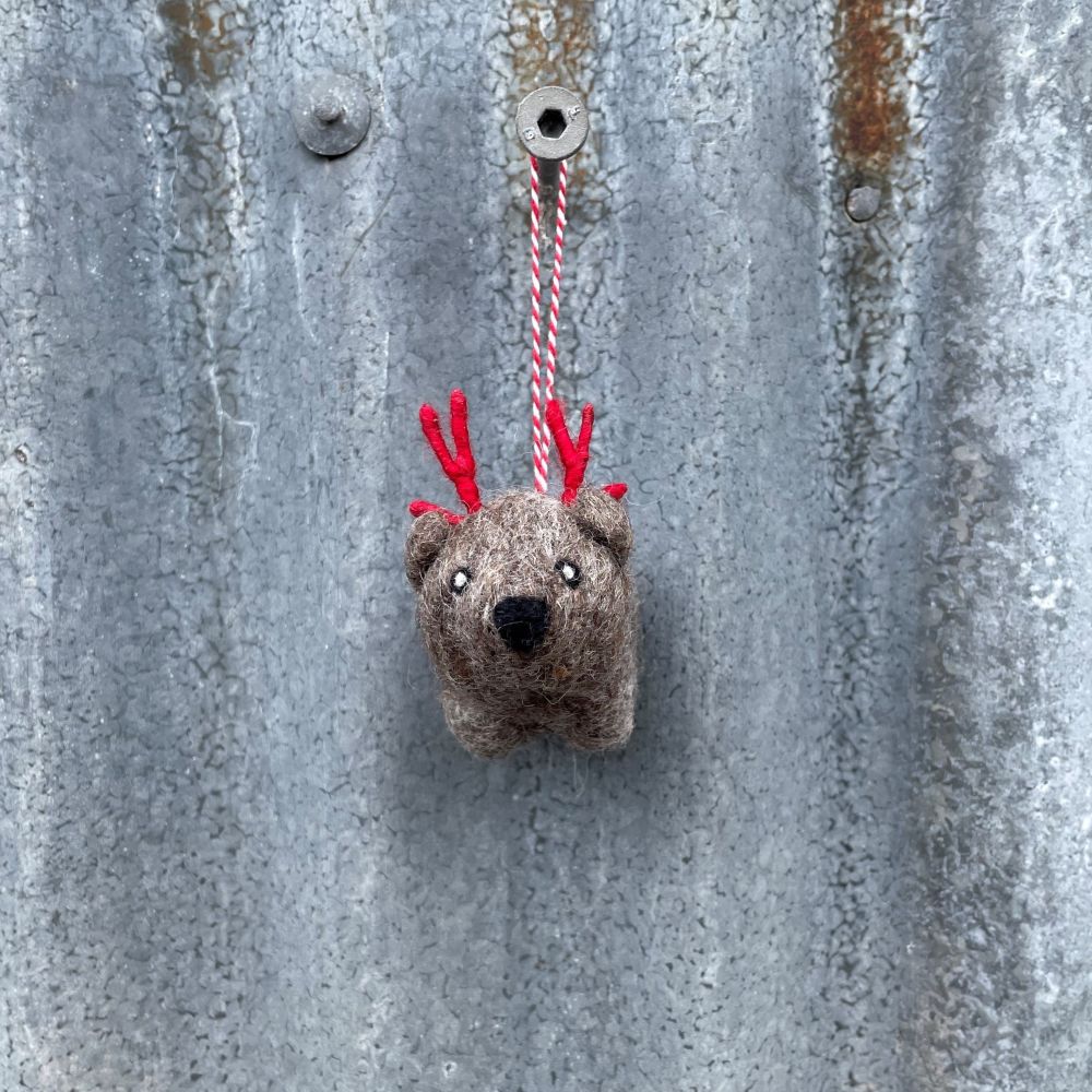 Small Australian Wombat ornament with red antlers hanging on a metal surface