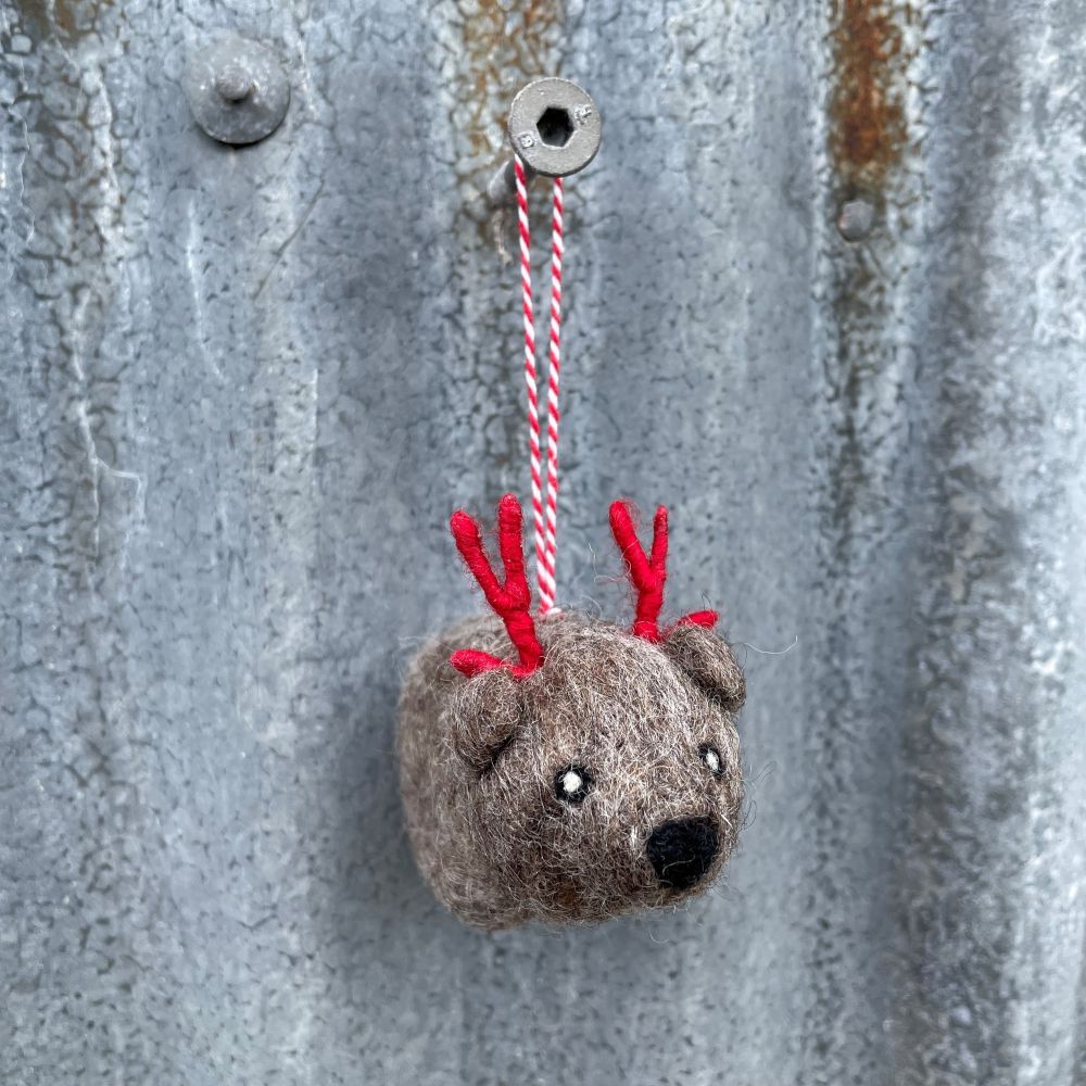 Small Felt Australian Wombat ornament with red antlers hanging on a metal surface