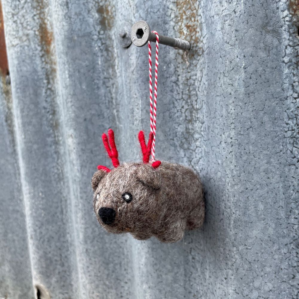 Small Australian Wombat ornament with red antlers hanging on a metal surface