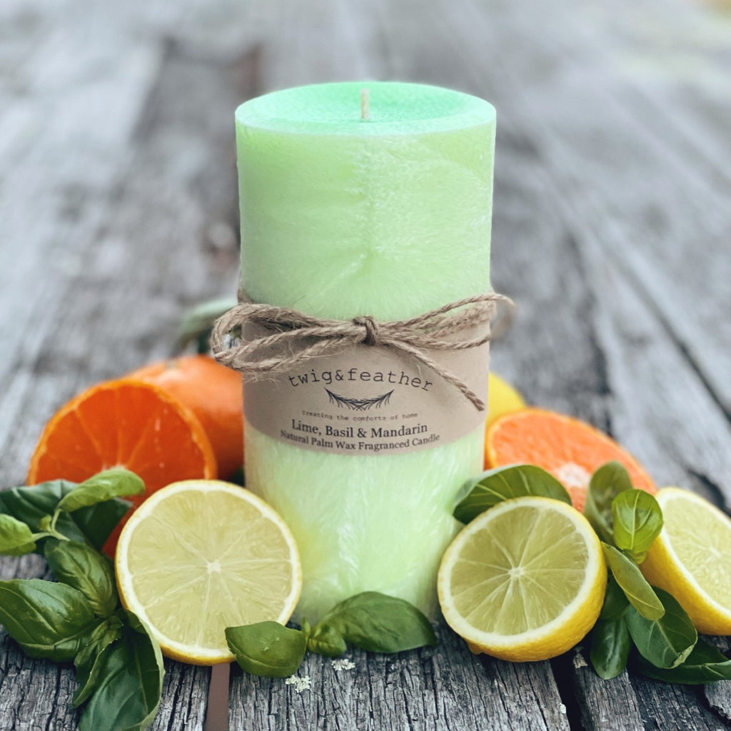 Twig and Feather Lime, Basil and Mandarin palm wax candle in lime Green colour surrounded by lime, mandarin and basil on a wooden surface - 80 hour candle