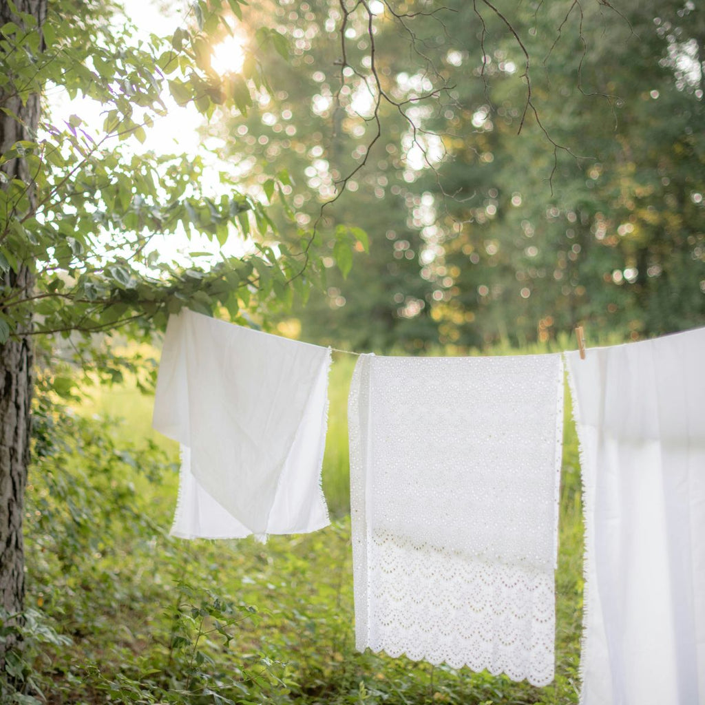 White towels hanging on a clothesline in a forest setting