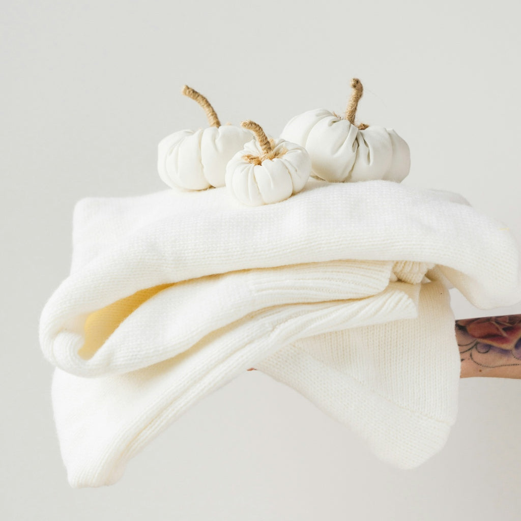 White blankets and sheets with small white pumpkins on a light gray background