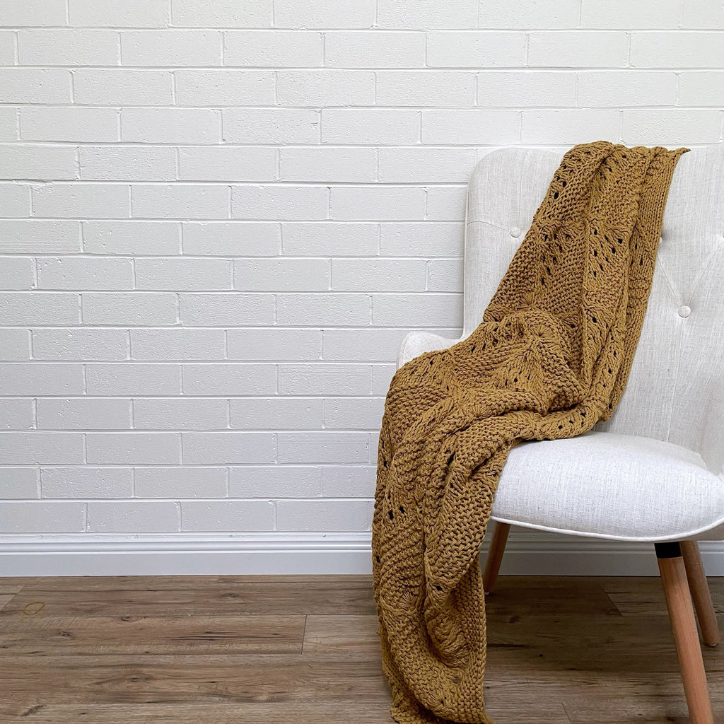 Twig-and-feather-hand-knitted-throw-mustard
